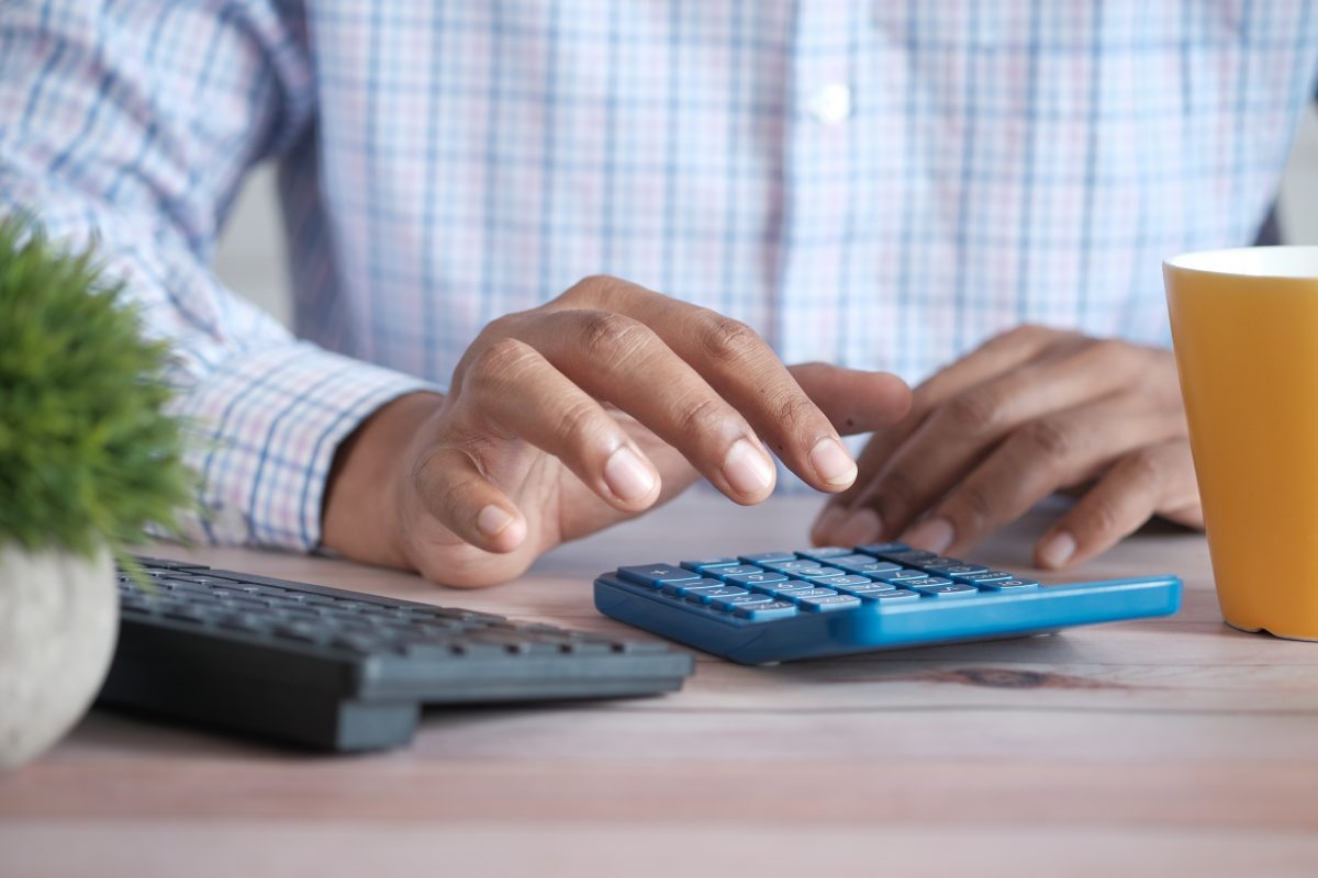 Close up of man hand using a calculator